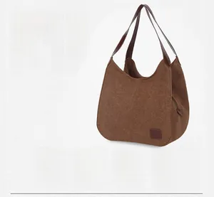 Vue détaillée du cabas en toile marron avec poignées en cuir et poche zippée pratique