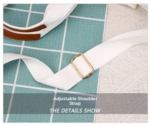 Detail of adjustable white canvas shoulder strap with gold buckle and leather accents
