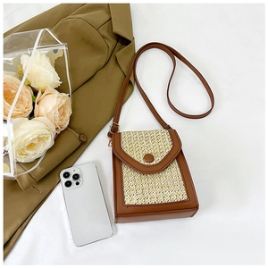 Vertical straw woven phone bag with brown leather trim and crossbody chain strap