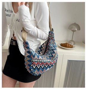 Detail einer farbenfrohen gewebten Tasche mit breitem hellbraunem Canvas-Schultergurt