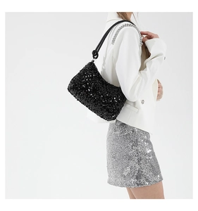 Close-up of black sequined shoulder bag featuring knot handle and silver chain detail