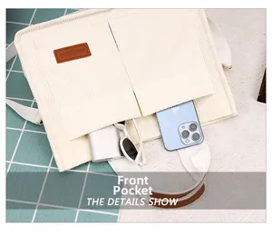 Detail view of corduroy tote bag featuring front pockets and soft cotton straps