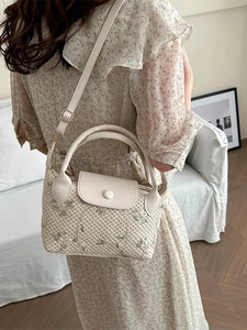 Sac à main tissé avec broderie florale et rabat en cuir crème dans un cadre de vie