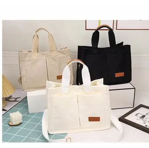 Three corduroy tote bags in cream, beige and black with front pockets and fashion patches