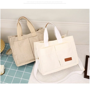 Detailed view of beige corduroy tote bag with large front pockets and adjustable strap