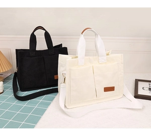 Detail of corduroy tote bag with front pockets and fashion tag in black and beige
