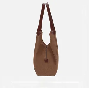Vue latérale du sac en toile avec garniture en cuir marron et détails de fermeture éclair