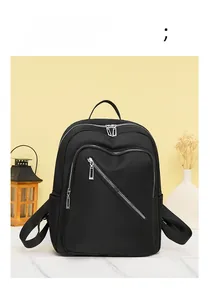Detailed view of black nylon backpack with multi-zipper design on a marble surface
