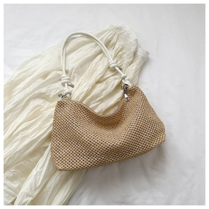 Detail of hand-woven straw shoulder bag with white knot handle and silver metal zipper