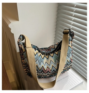 Detail der Boho-Zickzack-Stricktextur und verstellbarer Canvas-Gurt der Beuteltasche