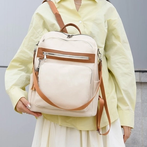 Women's chic beige canvas backpack with brown leather accents and multi-strap design