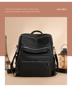 Detail of black pebbled leather backpack showing multi-zipper pockets and tassel decor