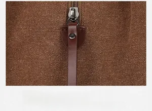 Détail d'un sac bandoulière en toile avec fermeture éclair et tirette en cuir