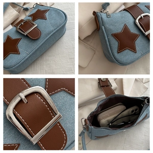 Detail view of denim underarm bag with leather star patch and spacious interior
