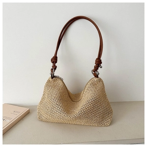 Close-up of woven straw shoulder bag featuring a hobo silhouette and brown leather strap