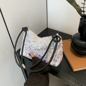 Sparkly white sequin baguette shoulder bag with a black knotted cord strap and zipper top
