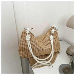 Macro shot of hand-woven straw tote bag with elegant white knotted rope handles