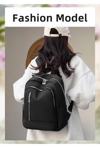 Rear view of model wearing a black nylon water-resistant backpack with multiple zippers
