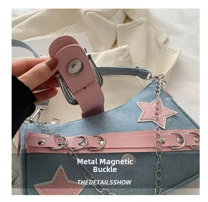 Close-up of secure silver magnetic snap closure and pink leather trim on denim star bag