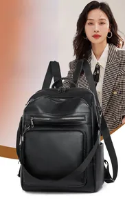 Detail of black PU leather backpack showing multiple zipper pockets and tassel charm
