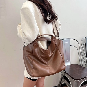 Brown leather large capacity tote bag shown on model for a trendy casual commuter style
