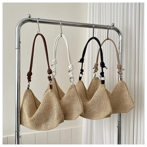 Detail of woven straw hobo bags in four colors with leather straps and zip closure