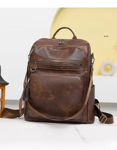 Detailed close-up of dark brown vintage backpack with multi-pocket design and fringe detail