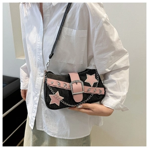Detail of black denim shoulder bag with pink leather stars and silver chain strap