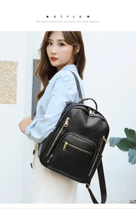 Detail view of stylish black leather backpack with gold zippers and multi-pocket design