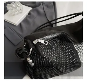 Détail de la fermeture éclair argentée et maille strass scintillante sur le sac en daim noir