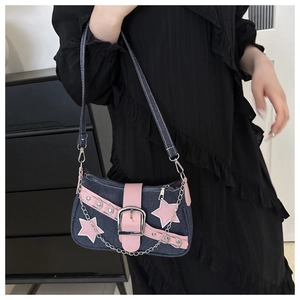 Y2K denim shoulder bag detail with pink star patches and metallic chain buckle