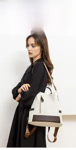 Detail of a chic woven texture backpack with contrast brown leather accents for women