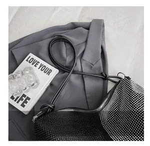 Détail d'un sac cabas à strass étincelants avec base noire et bandoulière à nœud élégante