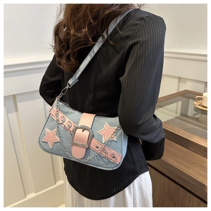 Close-up of Y2K denim star bag with pink leather patches and silver metal chain detail