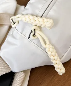 Detaillierte Nahaufnahme einer weißen Stoffgürteltasche mit geflochtenem Reißverschluss