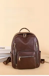 Detail of dark brown pebbled leather backpack with multiple zip pockets and top handle
