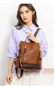 Detail of vintage brown PU leather woven backpack with metal zipper and wide straps
