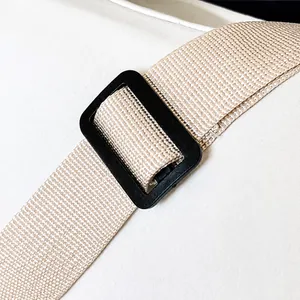 Detail eines verstellbaren beigen Nylon-Schultergurts mit schwarzer Kunststoffschnalle