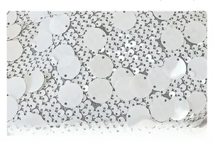 Detailed macro view of white embroidered sequins and delicate mesh on a crossbody bag