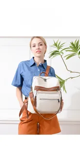 Close-up of beige lychee grain PU leather backpack featuring fringe and brown straps