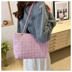 Detailed close-up of pink tweed tote bag texture with elegant gold chain strap