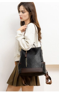 Detail of a vintage PU leather backpack featuring snakeskin texture and brown strap