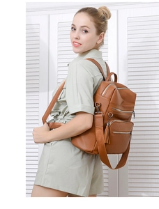 Detail of brown faux leather backpack with tassel zip and multi-layer storage