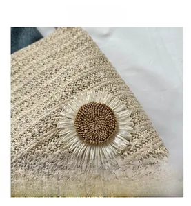 Detailed view of woven straw tote featuring a 3D daisy flower accent and natural texture