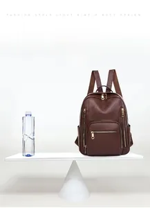 Lightweight brown leather backpack weighing 0.52kg shown on a scale for comparison