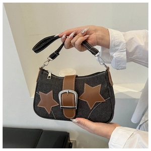 Detail of denim shoulder bag with leather stars and metal buckle in Y2K style
