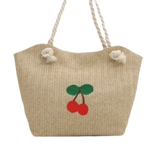 Sac en paille avec broderie cerise rouge et anses en corde de coton blanc sur fond blanc