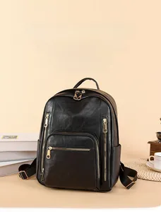 Close-up of black vintage leather backpack with golden zippers and texture details