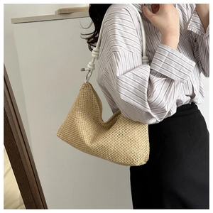 Detail of woven straw hobo bag with white rope strap and textured beige weave pattern