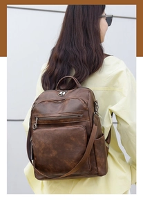 Brown vintage faux leather backpack detail showing natural texture and side view on model